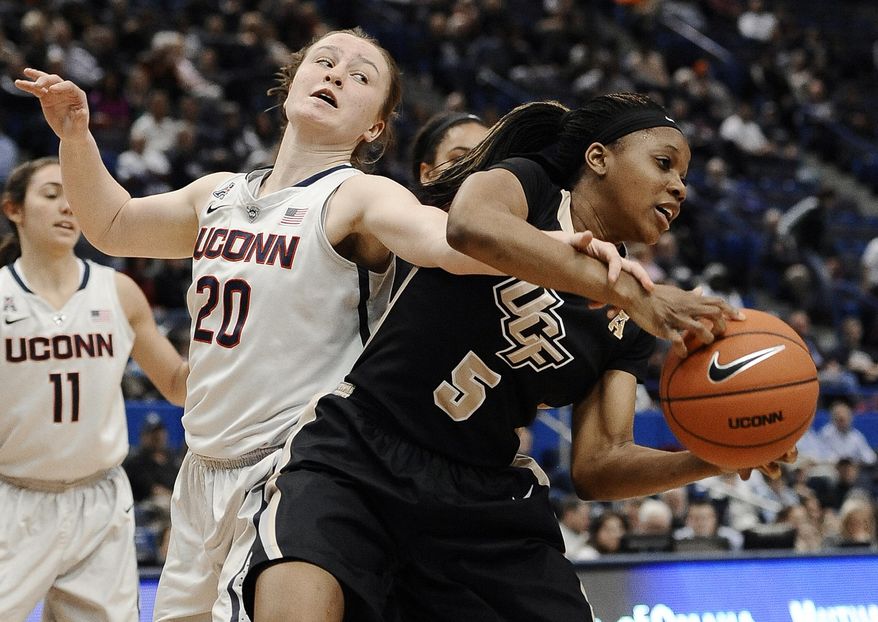 Connecticut's Tierney Lawlor, left, tangles with Central Florida's Zykira Lewis during the second half of an NCAA college basketball game, Wednesday, Feb. 19, 2014, in Hartford, Conn. (AP Photo/Jessica Hill)