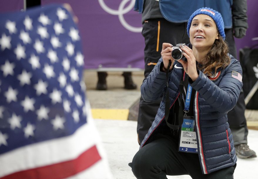 American bobsledder Lolo Jones takes pictures of her teammates after they won silver and bronze during the women's bobsled competition at the 2014 Winter Olympics, Wednesday, Feb. 19, 2014, in Krasnaya Polyana, Russia. (AP Photo/Michael Sohn)