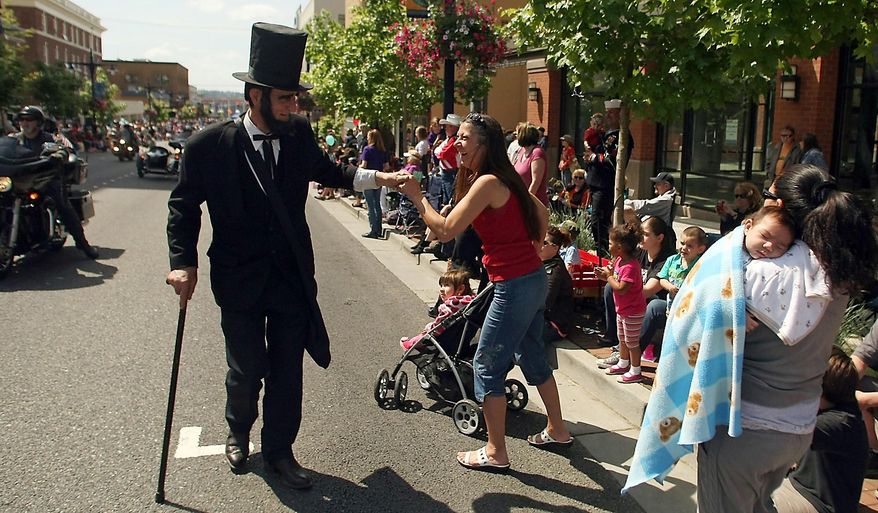 This May 19, 2012 file photo, Robert Brown plays the part of Abraham Lincoln, as he greets those along the 2012 Armed Forces Day Parade route. Brown, who portrayed Abraham Lincoln at the Armed Forces Day Parade and other patriotic events passed away Feb. 12, the 16th president's birthday. Brown lived in a cabin without power and water on 5 acres above Tahuya. He suffered a brain abscess on New Year's Day, underwent surgery at Harborview Medical Center in Seattle and was recovering at Life Care Center in Port Orchard when a seizure took his life, said former wife Rena Farrar. He was 72. (AP Photo/Kitsap Sun, Meegan M. Reid)