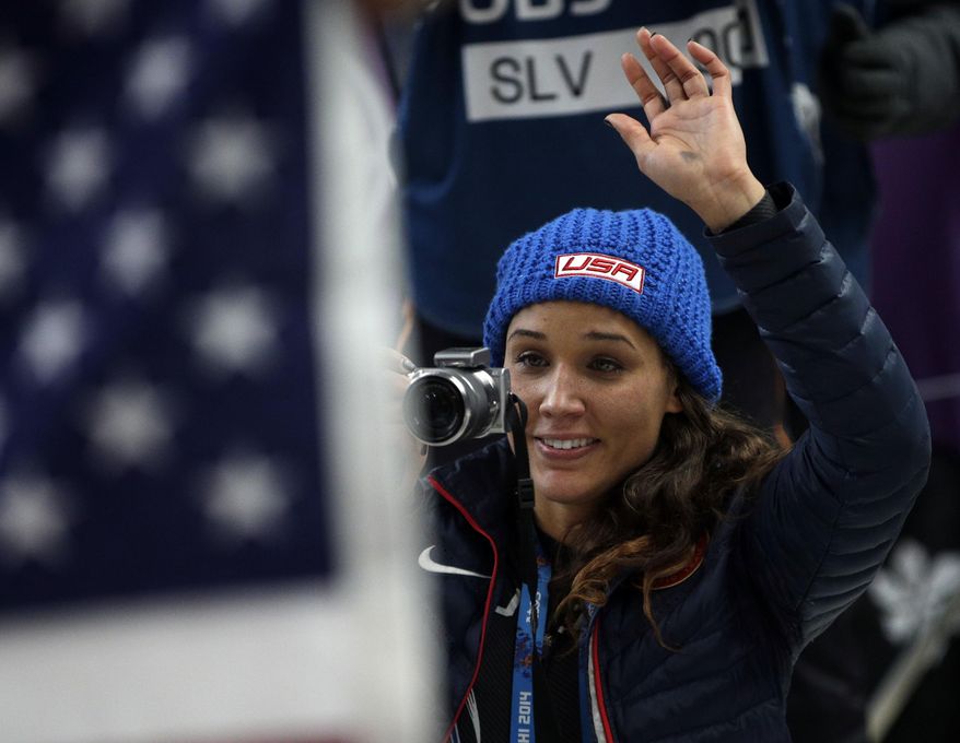 American bobsledder Lolo Jones takes pictures of her teammates after they won silver and bronze during the women's bobsled competition at the 2014 Winter Olympics, Wednesday, Feb. 19, 2014, in Krasnaya Polyana, Russia. (AP Photo/Michael Sohn)