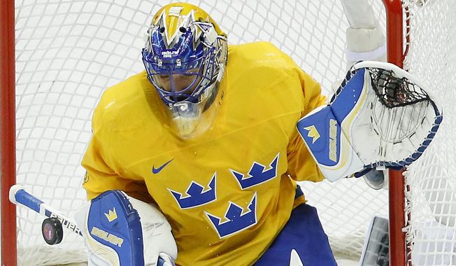 Sweden goaltender Henrik Lundqvist blocks a shot by Slovenia in the second period of a men&#x27;s ice hockey game at the 2014 Winter Olympics, Wednesday, Feb. 19, 2014, in Sochi, Russia. (AP Photo/Mark Humphrey)