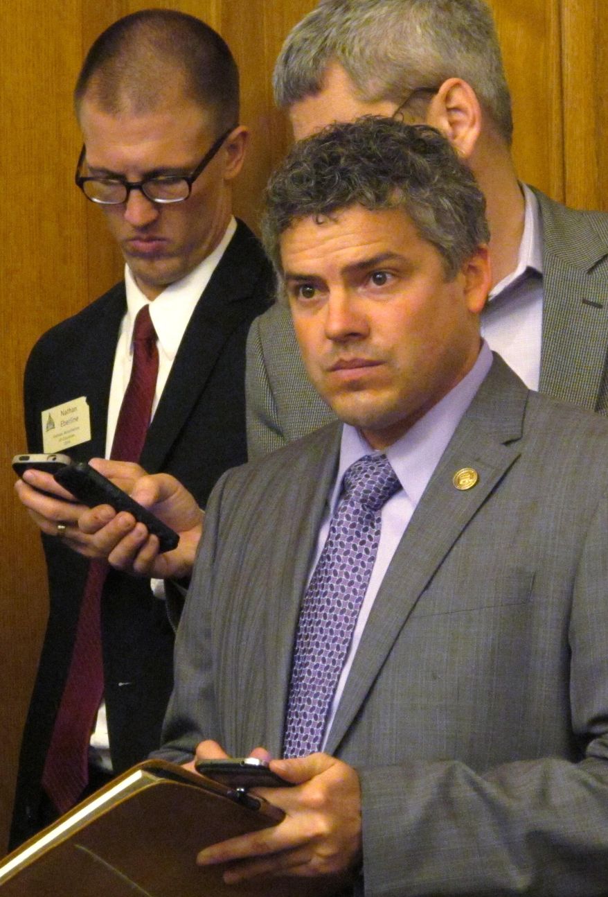 Kansas Republican Party Chairman Kelly Arnold follows a state Senate committee's debate on local elections legislation, Wednesday, Feb. 19, 2014, at the Statehouse in Topeka, Kan. The state GOP is pushing to move local elections to even-numbered years and make them partisan. (AP Photo/John Hanna)