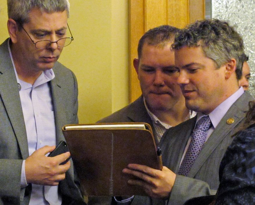 Kansas Republican Party officials confer during a state Senate committee debate on the GOP's proposal to change local elections, Wednesday, Feb. 19, 2014, at the Statehouse in Topeka, Kan. They are, right to left, Chairman Kelly Arnold, Political Director Heath Kohl and Executive Director Clay Barker. (AP Photo/John Hanna)