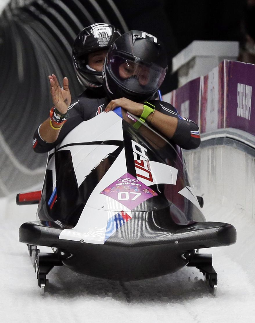 The team from the United States USA-3, piloted by Jazmine Fenlator with brakeman Lolo Jones, left, wave to fans after their final run during the women's bobsled competition at the 2014 Winter Olympics, Wednesday, Feb. 19, 2014, in Krasnaya Polyana, Russia. (AP Photo/Michael Sohn)