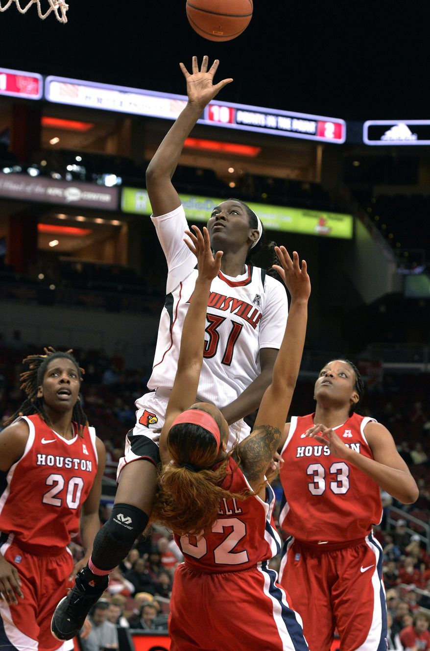 Louisville's Asia Taylor, center, shoots over the defense of Houston's Te'onna Campbell during the first half of an NCAA college basketball game Wednesday, Feb. 19, 2014, in Louisville, Ky. Left is Houston's Yasmeen Thompson, and right is Tyler Gilbert.(AP Photo/Timothy D. Easley)
