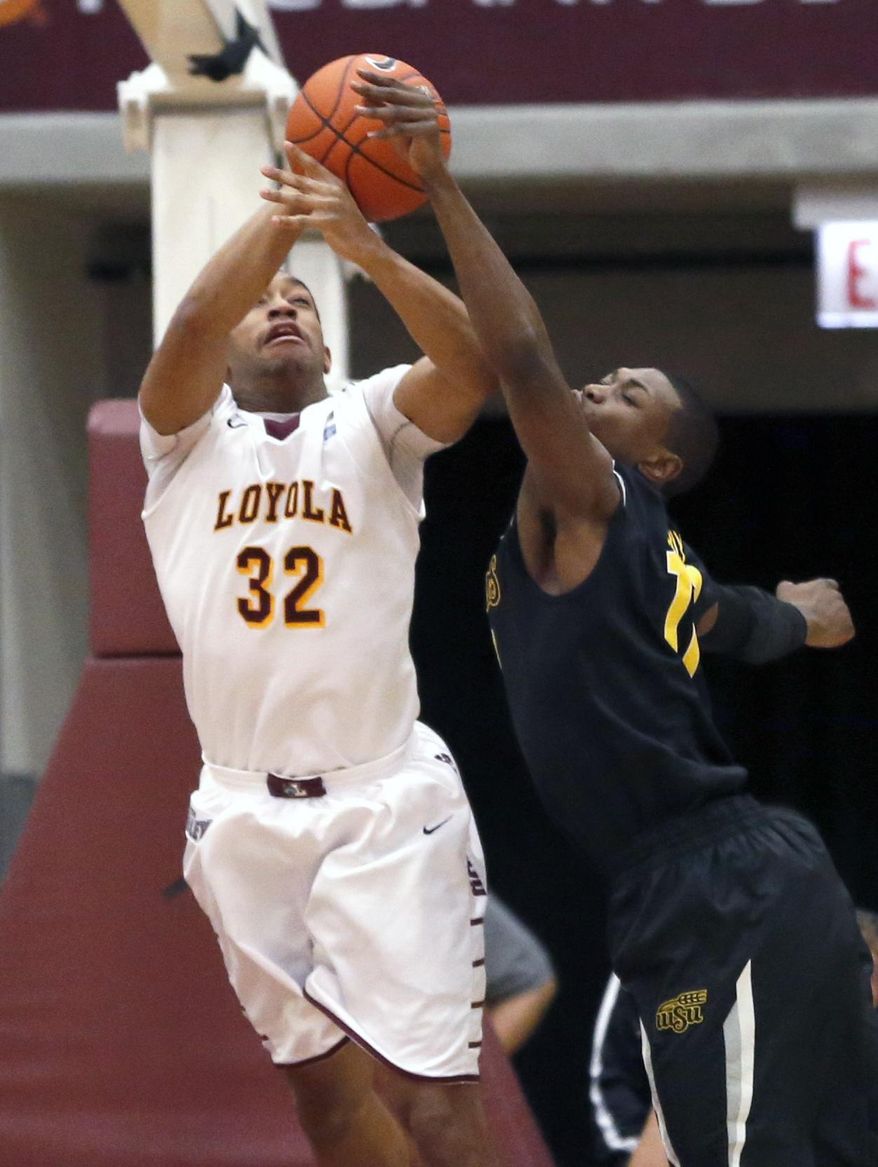 Wichita State forward Cleanthony Early (11) challenges Loyola of Chicago guard/forward Christian Thomas (32) during the first half of an NCAA college basketball game Wednesday, Feb. 19, 2014, in Chicago. (AP Photo/Charles Rex Arbogast)