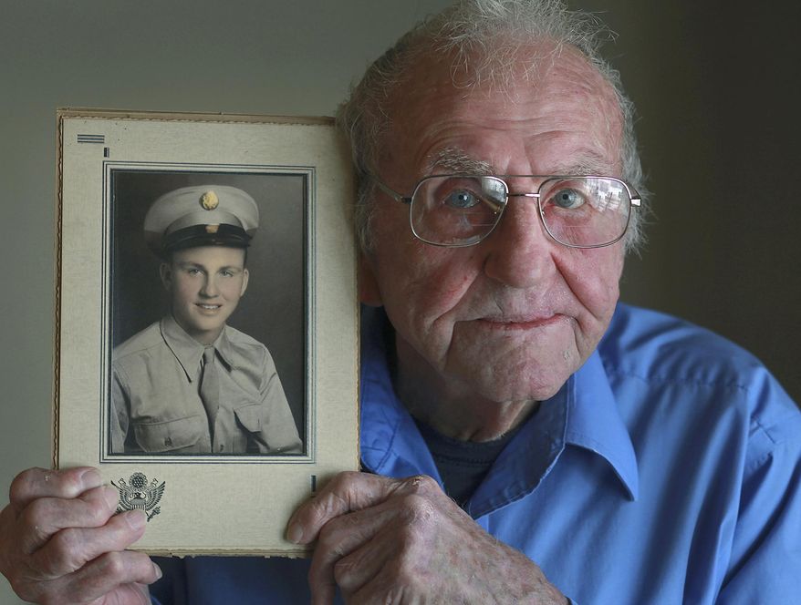 ADVANCE FOR USE SATURDAY, FEB. 22 AND THEREAFTER - In this Jan. 31, 2014, 2014 photo, World War II veteran Lynold Puterbaugh holds a portrait of him in his Army uniform that was taken in 1944 at his home in Pleasant Hill, Ill. (AP Photo/The Quincy Herald-Whig, Phil Carlson)