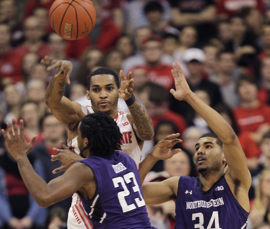 Ohio State's LaQuinton Ross, top left, passes the ball over Northwestern's JerShon Cobb, left, as Sanjay Lumpkin helps on defense during the first half of an NCAA college basketball game Wednesday, Feb. 19, 2014, in Columbus, Ohio. (AP Photo/Jay LaPrete)