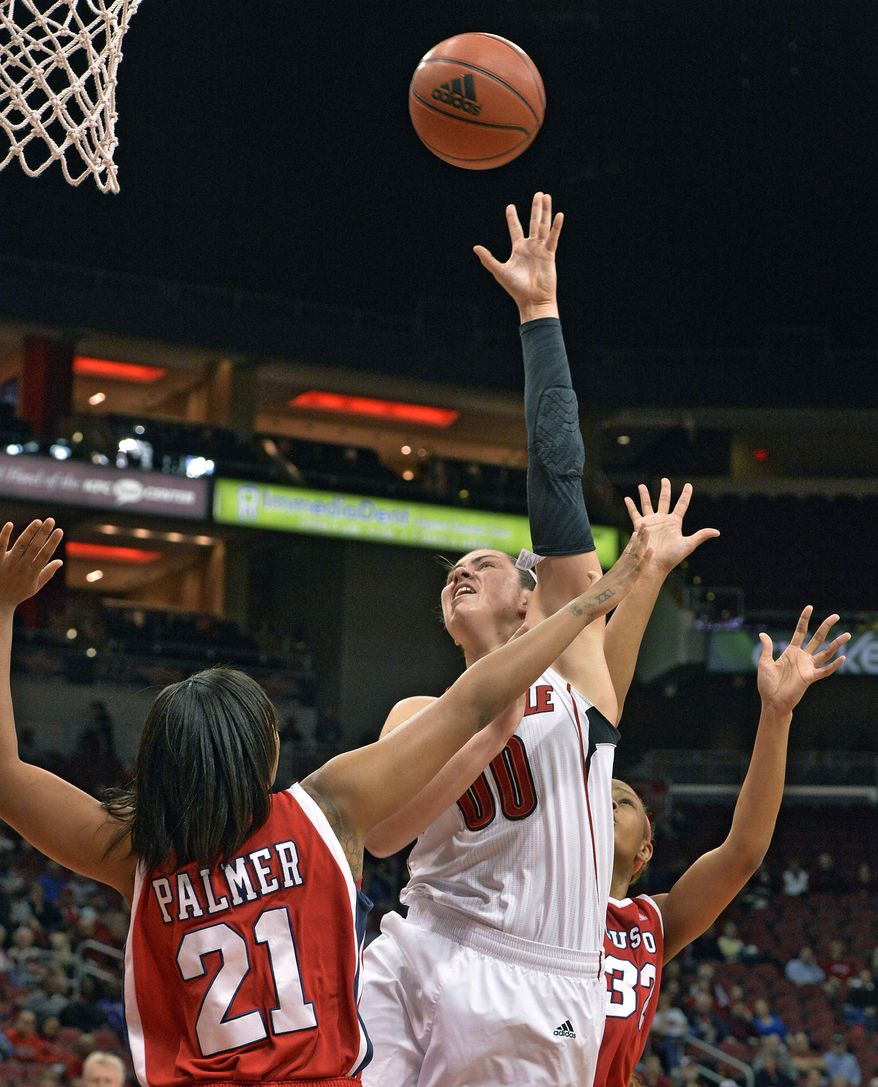 Louisville's Sara Hammond, center, puts up a shot over the defense of Houston's Jessieka Palmer, left, and Te'onna Campbell during the first half of an NCAA college basketball game Wednesday, Feb. 19, 2014, in Louisville, Ky. (AP Photo/Timothy D. Easley)