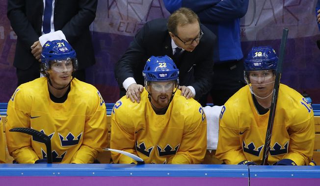 Sweden coach Par Marts congratulates players, from left, forward Loui Eriksson, Sweden forward Daniel Sedin and forward Nicklas Backstrom after a goal against Slovenia in the third period of a men&#x27;s ice hockey game at the 2014 Winter Olympics, Wednesday, Feb. 19, 2014, in Sochi, Russia. Sweden won 5-0. (AP Photo/Mark Humphrey)