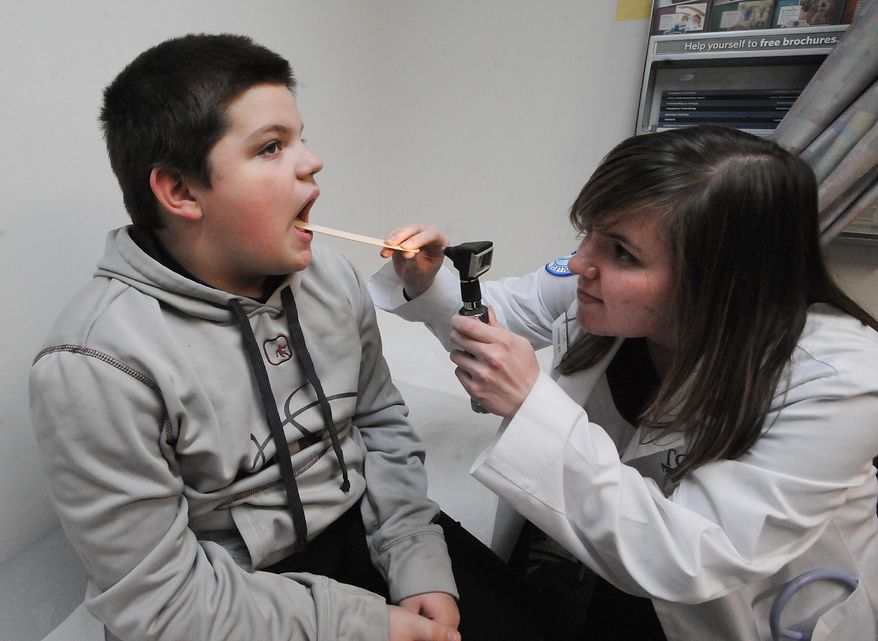 Second year medical student from The Commonwealth Medical College, Stephanie Veit checks the throat of Jeffery Meader at the Rural Health Corporation on Feb. 11, 2014 in Monroe Township, Pa. The Continuity Mentor program with TCMC offers students a unique opportunity to develop a learning relationship with area doctors and patients. The integrated learning atmosphere helps to reinforce what the student is learning academically with supervised hands-on experience. (AP Photo/The Times Leader, Clark Van Orden ) CITIZENS' VOICE OUT; SCRANTON TIMES OUT; STANDARD-SPEAKER OUT