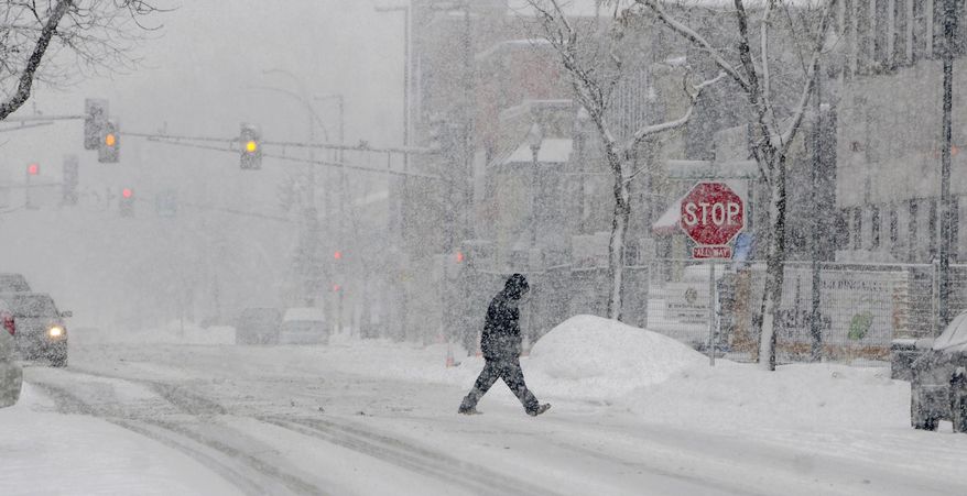 Heavy snow falls in downtown St. Cloud, Minn., Thursday, Feb. 20, 2014. (AP Photo/The St. Cloud Times, Dave Schwarz)