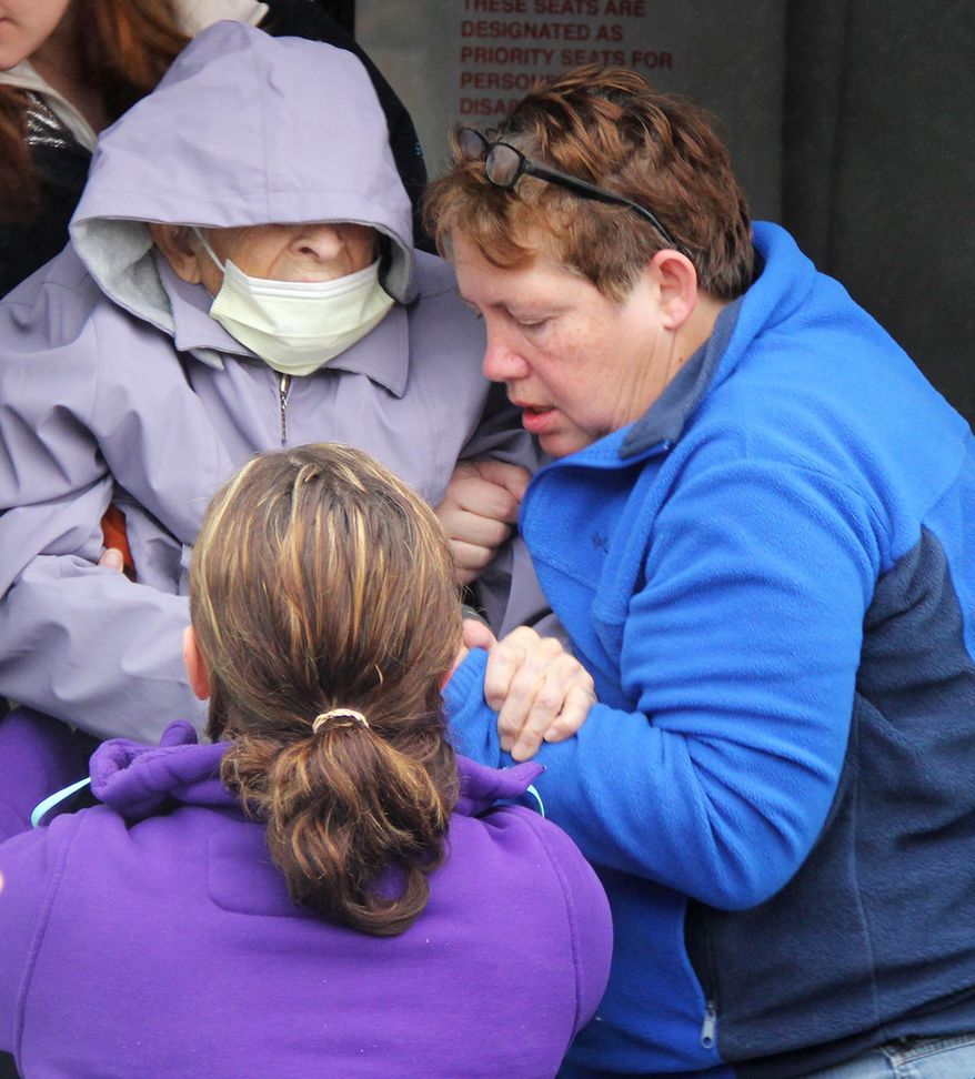 Donna Hovey, right, and Nicole Wahl, front, assist 100-year-old Margaret Godfrey down the steps of a bus Thursday, Feb. 20, 2014, in Kensett, Iowa after Northwood residents were evacuated to the Kensett Community Center, about six miles away, following a chemical fire at a fertilizer plant in Northwood. The women worked for Lutheran Retirement Home in Northwood, Iowa, which had been evacuated because of the fire. Northwood has a population of about 2,000 people. (AP Photo/Albert Lea Tribune, )