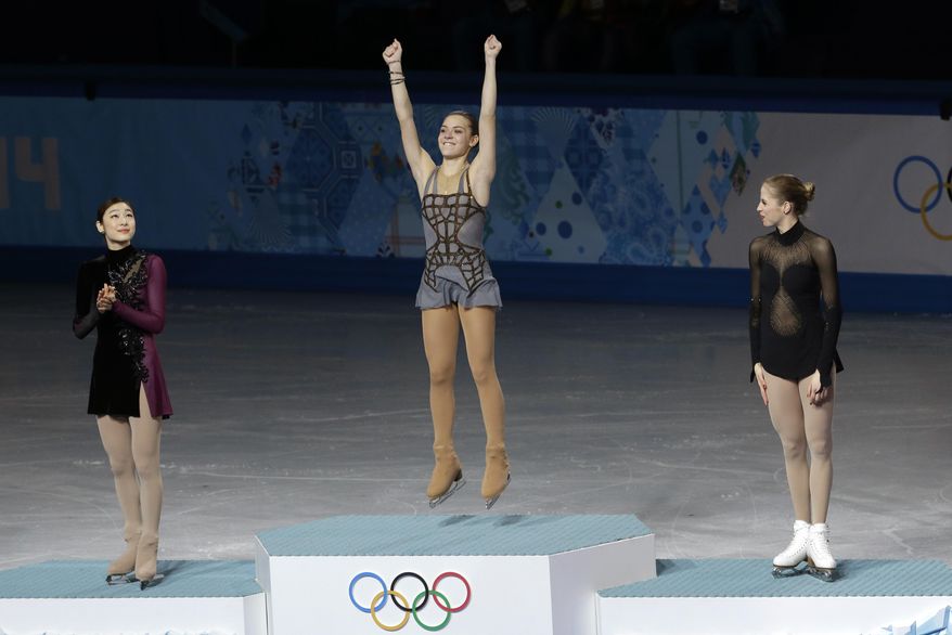 Adelina Sotnikova of Russia, centre, Yuna Kim of South Korea, left, and Carolina Kostner of Italy stand on the podium during the flower ceremony for the women's free skate figure skating final competes in the women's free skate figure skating finals at the Iceberg Skating Palace during the 2014 Winter Olympics, Thursday, Feb. 20, 2014, in Sochi, Russia. Sotnikova placed first, followed by Kim and Kostner. (AP Photo/Darron Cummings)