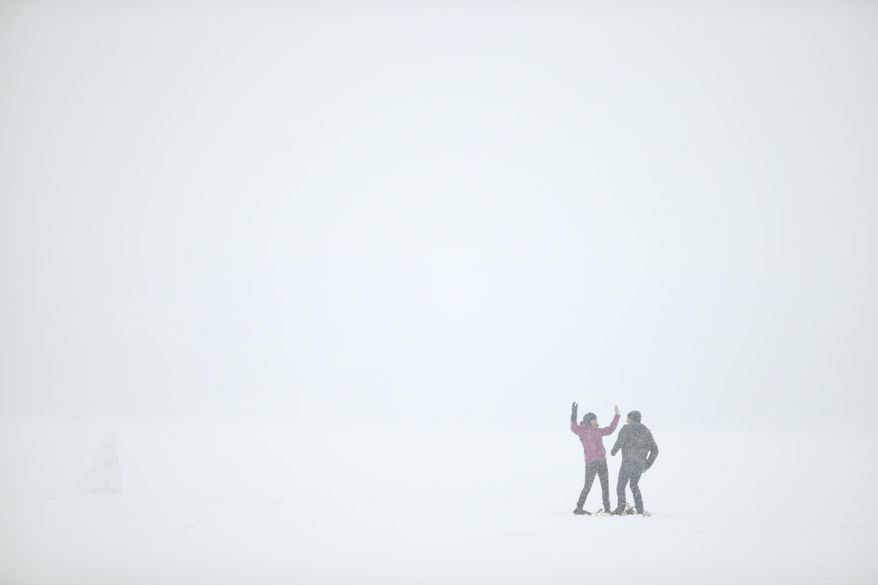 What forecasters say might be the largest snowfall of the winter began falling Thursday, Feb. 20, 2014 in Minneapolis. Theodore Kimble got down on his knees and asked Olivia Joy to marry him after they snowshoed out to the middle of Lake Harriet and made a snow man Thursday afternoon. They made the snowshoes themselves. She said "yes". (AP Photo/The Star Tribune, Jeff Wheeler)