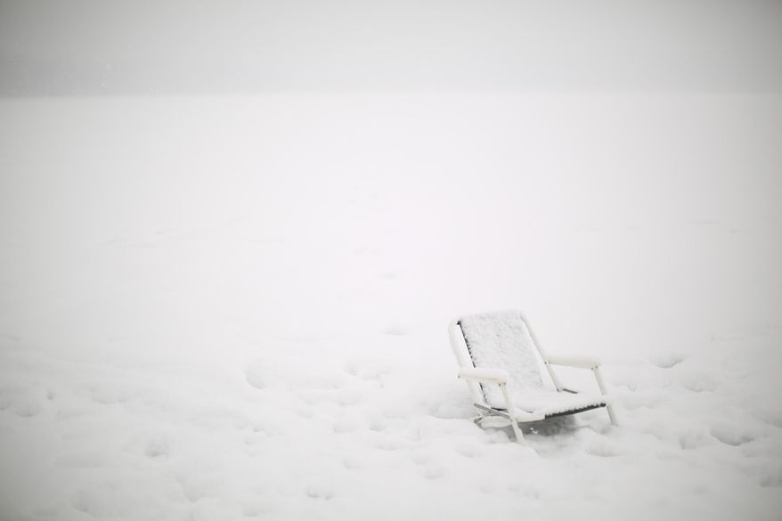 What forecasters say might be the largest snowfall of the winter began falling Thursday, Feb. 20, 2014 in Minneapolis. A chair on the ice at the south end of Lake Harriet Thursday afternoon. (AP Photo/The Star Tribune, Jeff Wheeler)