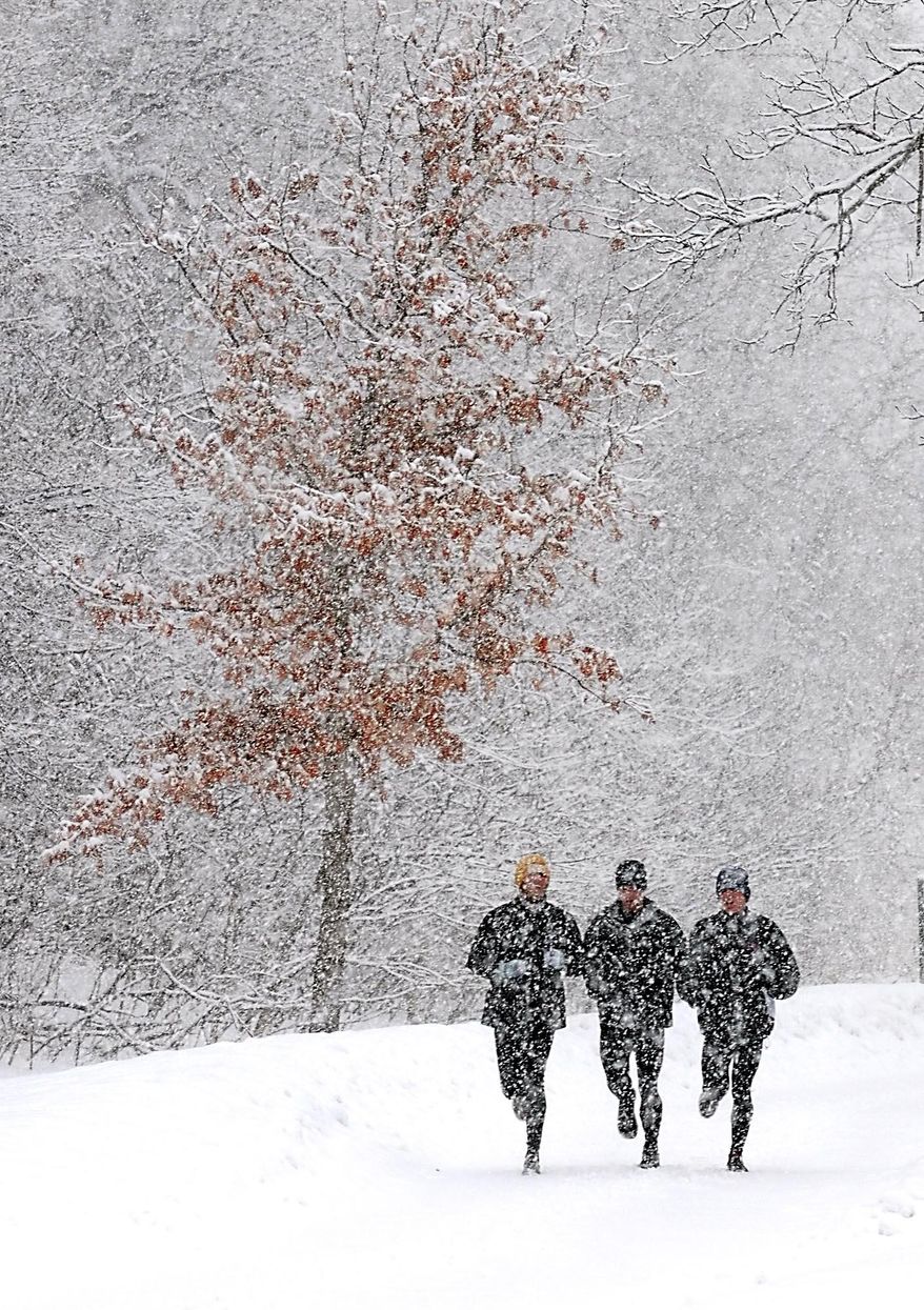 A trio of runners brave a winter storm to go for a run Thursday, Feb. 20, 2014, in Mankato. A winter storm moving into the area created slick roads and threatened to put 5 to 8 inches of fresh snow on the ground in the region. (AP Photo/Mankato Free Press, Pat Christman)
