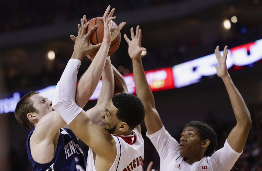 Penn State's Donovon Jack, left, Nebraska's Walter Pitchford, center, and David Rivers, right, struggle for a rebound in the first half of an NCAA college basketball game in Lincoln, Neb., Thursday, Feb. 20, 2014. (AP Photo/Nati Harnik)