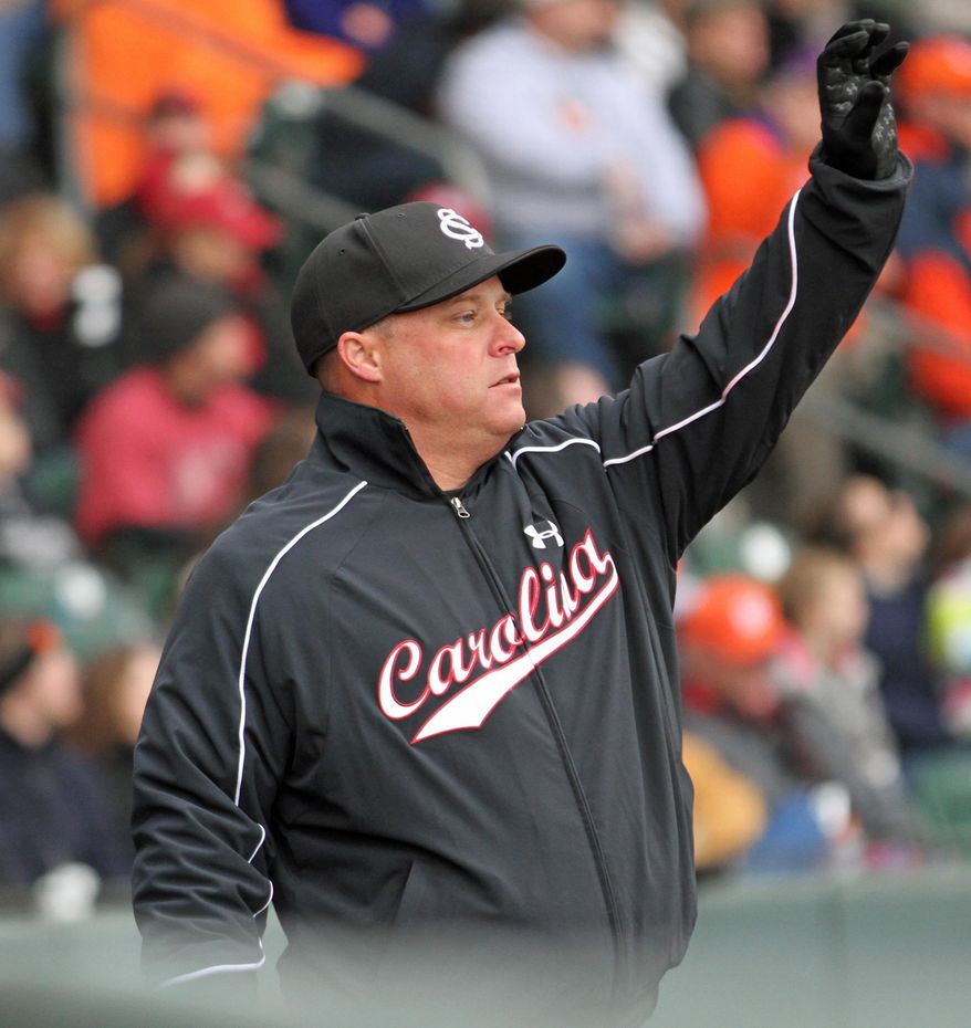 ADVANCE FOR WEEKEND EDITIONS, FEB. 22-23 - FILE - In this March 2, 2013 file photo, South Carolina head coach Chad Holbrook signals an outfield shift during an NCAA college baseball game against Clemson at Fluor Field in Greenville, S.C. (AP Photo/Anderson Independent-Mail, Mark Crammer, File)  GREENVILLE NEWS OUT, SENECA NEWS OUT