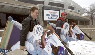 Montreal Expos fans Jean-Franois Reid, left, and Dave Kaufman leave with team souvenirs as the Expos store is holding a liquidation sale at the Olympic Stadium on Friday, Dec. 3, 2004. (AP PHOTO/La Presse, Andr Pichette)