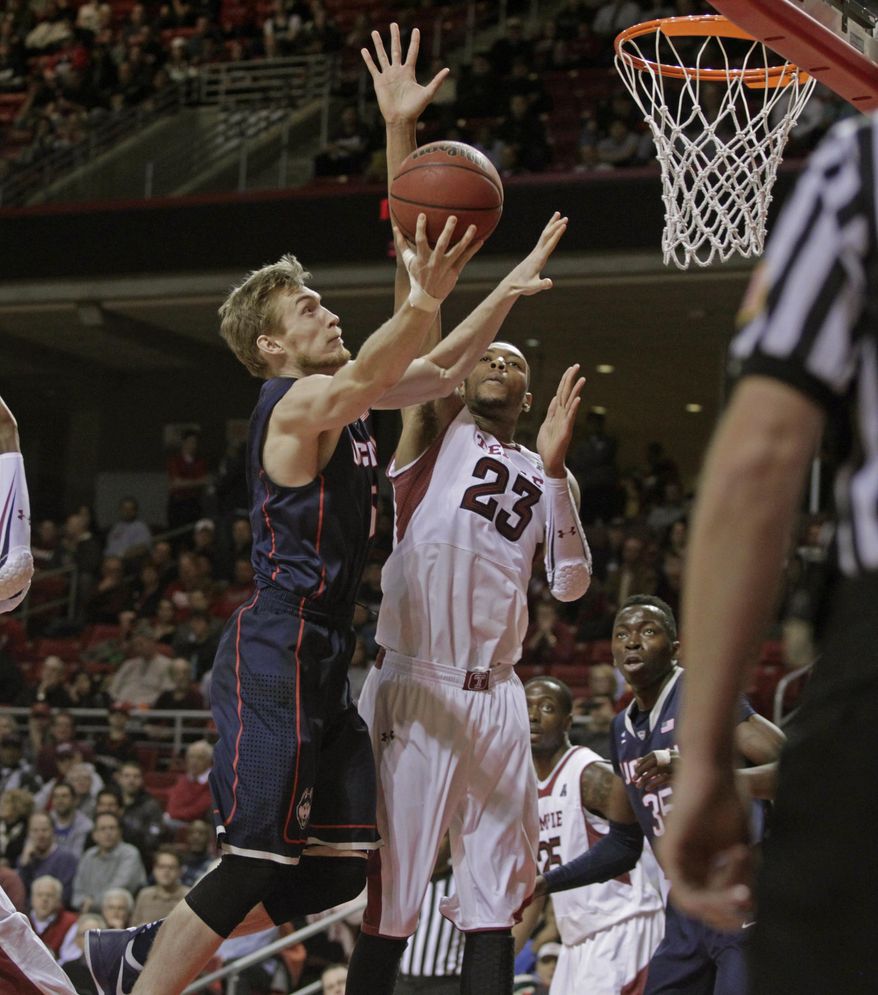 Connecticut's Niels Giffey, left shoots as Temple's Devontae Watson (23) defends in the first half of an NCAA college basketball game, Thursday, Feb. 20, 2014 in Philadelphia. (AP Photo/H. Rumph Jr.)