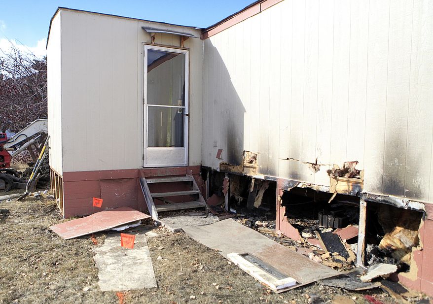 This Feb. 18, 2014 photo shows the trailer home owned by David Tolley in Wheel Estates, that was significantly damaged by a fire that started below the house in Rapid City, S.D. (AP Photo/Raid City Journal, Chris Huber)