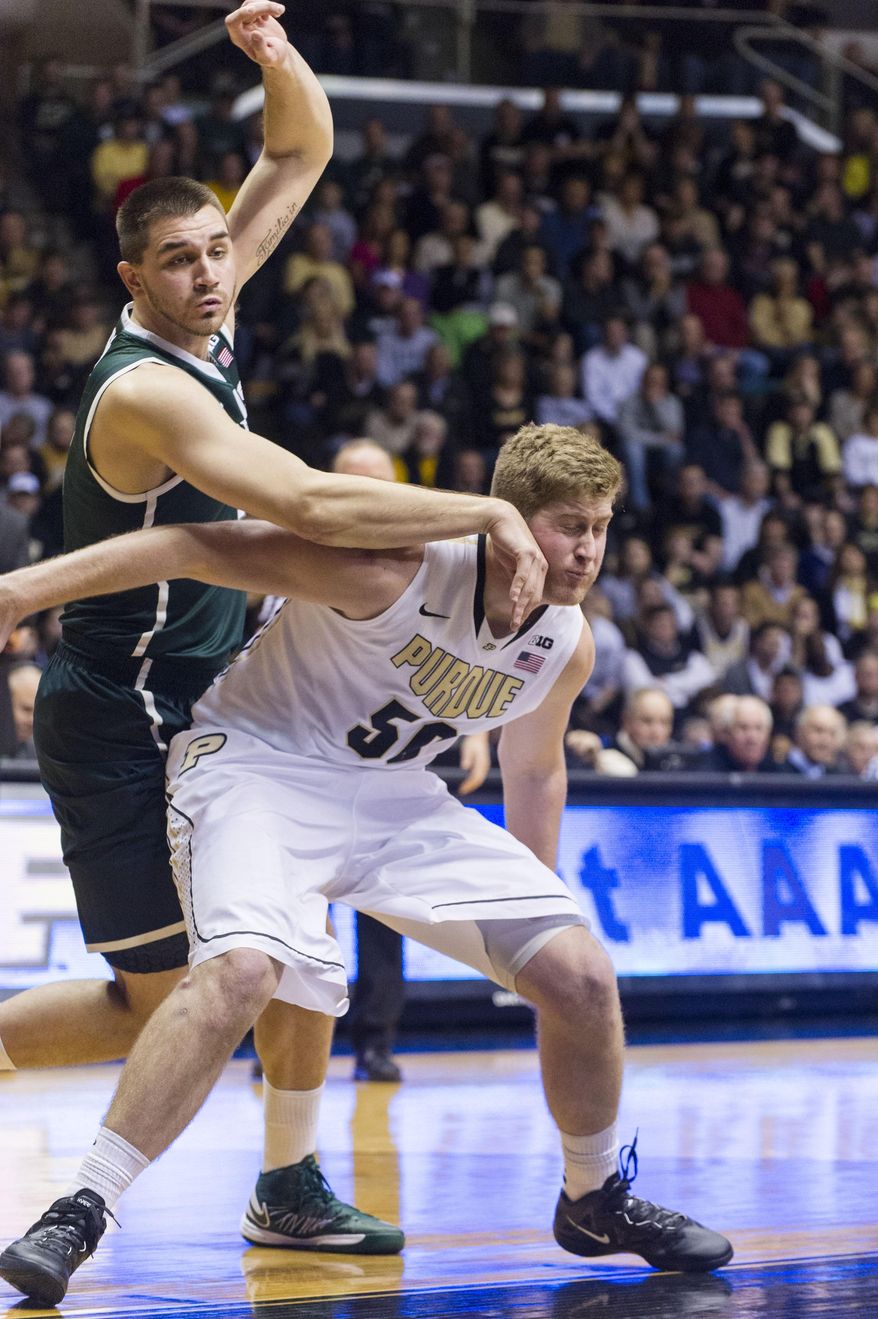 Purdue’s Travis Carroll (50)  battles for position under the basket with Michigan State’s Kenny Kaminski (30) in the first half of an NCAA college basketball game, Thursday, Feb. 20, 2014, in West Lafayette, Ind. (AP Photo/Doug McSchooler)