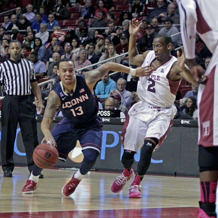 Connecticut's Shabzz Napier (13) drives against Temple's Will Cummings (2) in the first half of an NCAA college basketball game, Thursday, Feb. 20, 2014 in Philadelphia. (AP Photo/H. Rumph Jr.)