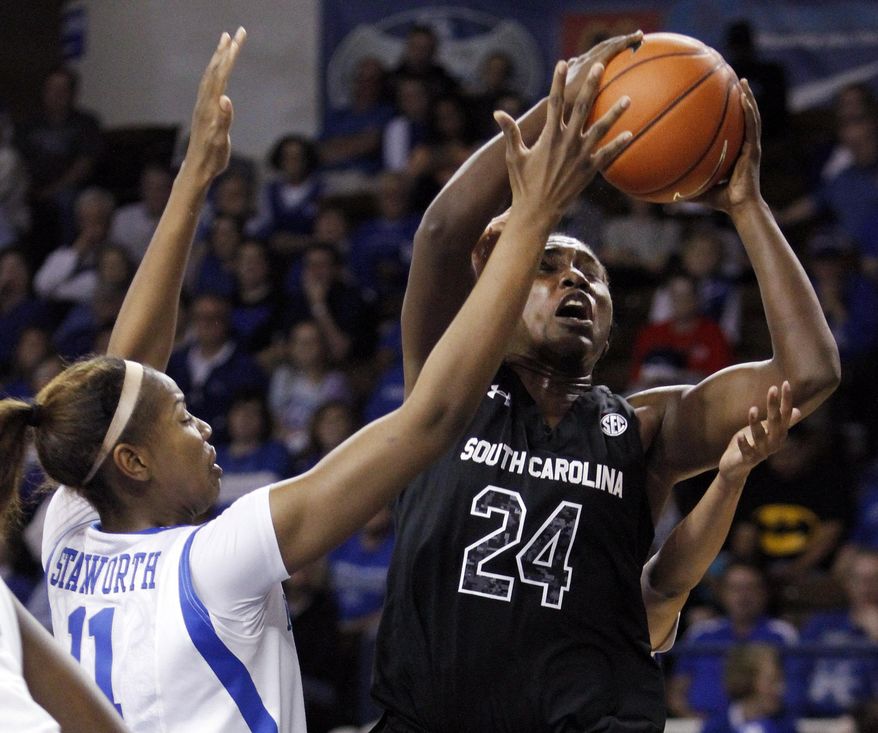 South Carolina's Aleighsa Welch (24) shoots under pressure from Kentucky's DeNesha Stallworth (11) during the first half of an NCAA college basketball game, Thursday, Feb. 20, 2014, in Lexington, Ky. (AP Photo/James Crisp)