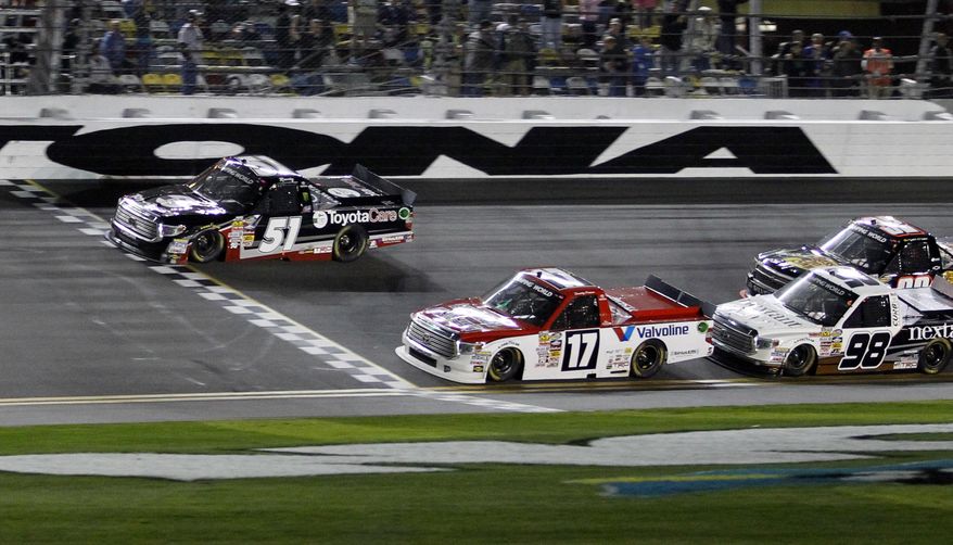 Kyle Busch (51) crosses the finish line ahead of Timothy Peters (17) to win the NASCAR Truck Series auto race at Daytona International Speedway in Daytona Beach, Fla., Friday, Feb. 21, 2014. (AP Photo/Terry Renna)
