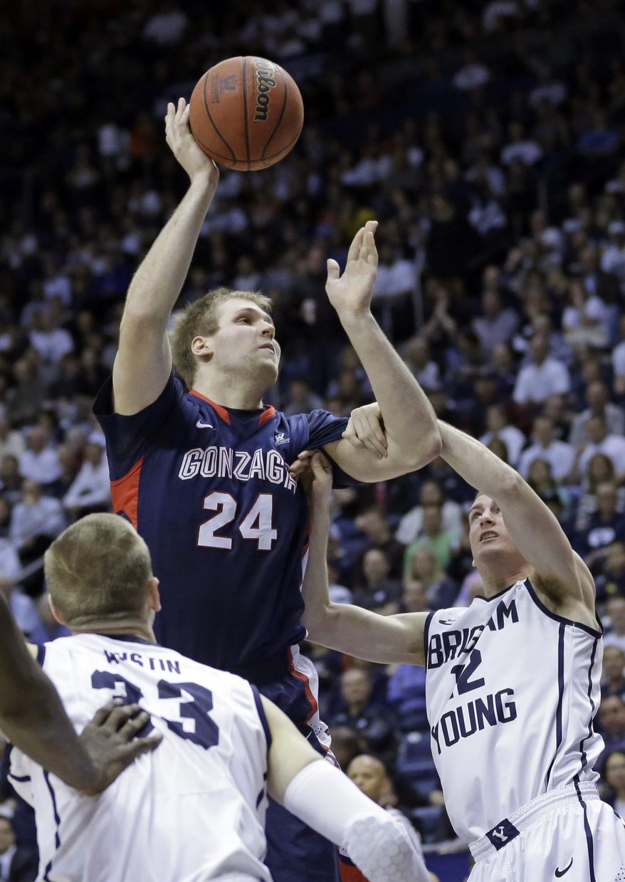Gonzaga's Przemek Karnowski (24) shoots as Brigham Young's Josh Sharp (12) defends in the first half of an NCAA college basketball game Thursday, Feb. 20, 2014, in Provo, Utah. (AP Photo/Rick Bowmer)