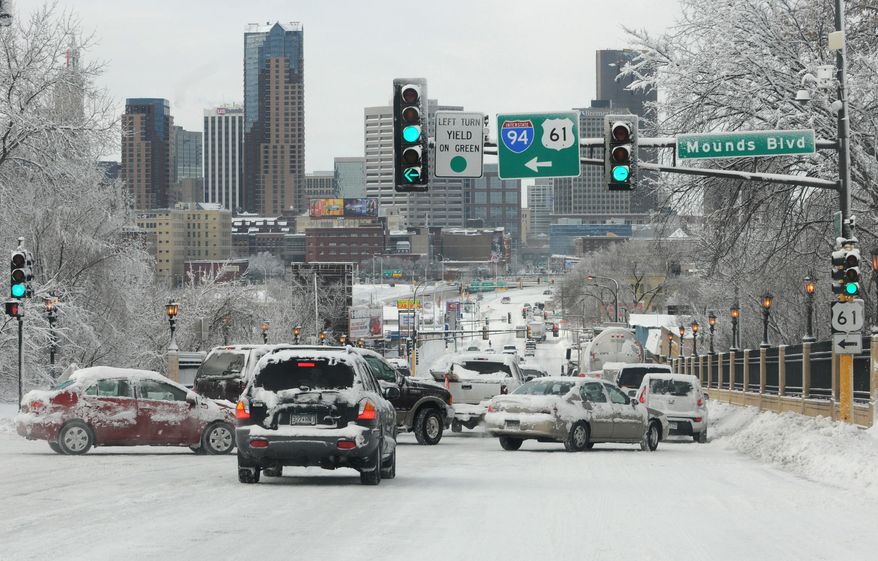 Traffic moves slowly on East Seventh Street at Mounds Boulevard Friday, Feb. 21, 2014. An intense winter storm closed Twin Cities schools, cut power to thousands and produced some of the worst driving conditions in recent memory. (AP Photo/The St. Paul Pioneer Press, Jean Pieri) MINNEAPOLIS STAR TRIBUNE OUT