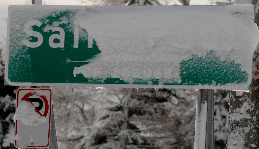Snow covers this "Saint Paul" sign at the border of St. Paul, Minn. on Friday, Feb. 21, 2014. An intense winter storm closed Twin Cities schools, cut power to thousands and produced some of the worst driving conditions in recent memory. Both St. Paul and Minneapolis declared snow emergencies Thursday afternoon. (AP Photo/The St. Paul Pioneer Press, Jean Pieri) MINNEAPOLIS STAR TRIBUNE OUT