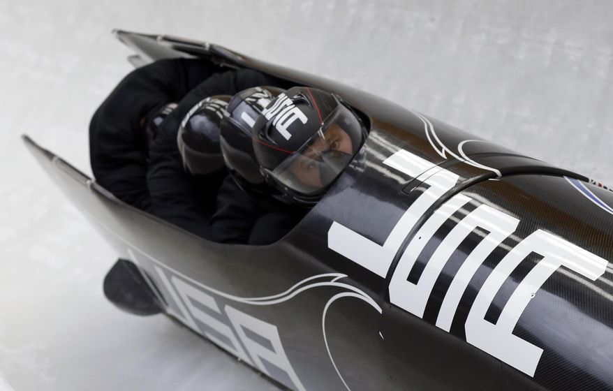 The team from the United States USA-1, piloted by Steven Holcomb, take a curve during the men's four-man bobsled training at the 2014 Winter Olympics, Friday, Feb. 21, 2014, in Krasnaya Polyana, Russia. (AP Photo/Natacha Pisarenko)