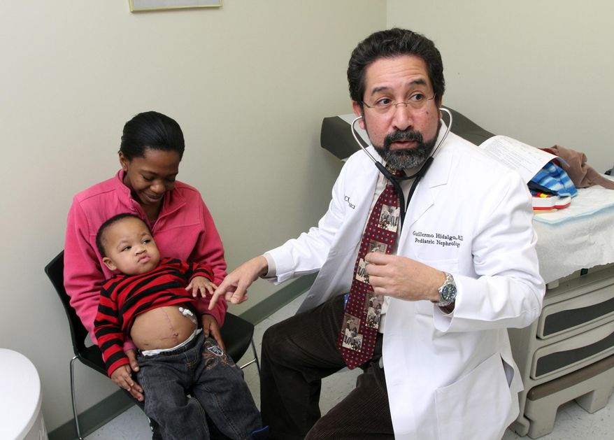 FOR RELEASE SUNDAY, FEBRUARY 23, 2014, AT 12:01 A.M. EST - In this Feb. 4, 2014 photo, Jessica Vick, left, holds her son, Jasiah Macon, while Dr. Guillermo Hidalgo prepares to examine the toddler, in Greenville, N.C. In December, Jasiah received his mother's kidney, becoming the youngest kidney transplant patient at Vidant Medical Center. (AP Photo/The Wilson Times, Gray Whitley)