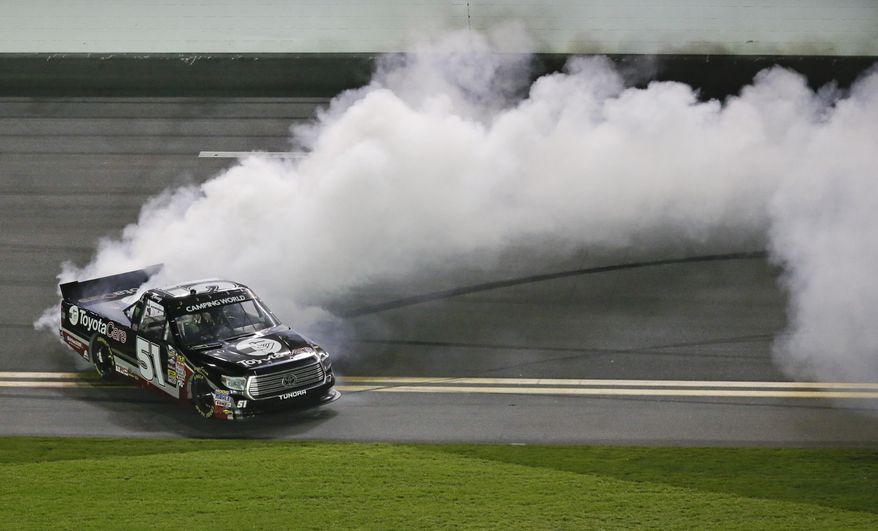 Kyle Busch spins his truck in a burnout after winning the NASCAR Truck Series auto race at Daytona International Speedway in Daytona Beach, Fla., Friday, Feb. 21, 2014. (AP Photo/John Raoux)