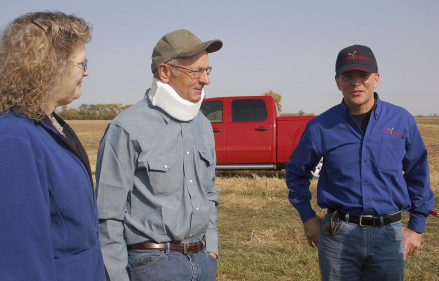 FILE - In this Sept. 27, 2012 file photo, Rose and Dan Dotzenrod, left, talk with Farm Rescue founder and president Bill Gross at the their farm near Wyndmere, N.D. The Dotzenrods were the 200th family to receive assistance from the group that helps farmers who are in need. The North Dakota-based nonprofit that helps farm families plant and harvest their crops is branching out into haying assistance. Farm Rescue is accepting applications from farmers in North Dakota, South Dakota, Minnesota, Iowa and eastern Montana. (AP Photo/Dave Kolpack, File)