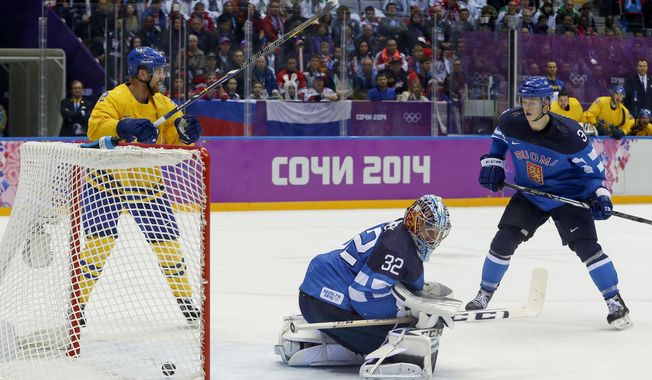 The puck, shot by Sweden defenseman Erik Karlsson, gets past Finland goalkeeper Kari Lehtonen for a goal during the second period of a men&#x27;s semifinal ice hockey game at the 2014 Winter Olympics, Friday, Feb. 21, 2014, in Sochi, Russia. (AP Photo/Julio Cortez)