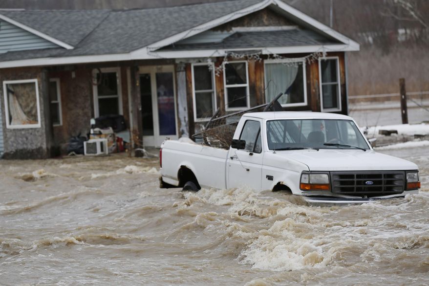 Flood waters surround a pickup and a home Friday, Feb. 21, 2014, on Barton Beach Road in Lafayette, Ind. Authorities say an ice jam has caused a creek near Lafayette to overflow its banks, flooding several homes and prompting some evacuations. (AP Photo/Journal & Courier, John Terhune)