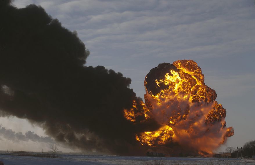 FILE - In this Dec. 30, 2013 file photo, a fireball goes up at the site of an oil train derailment in Casselton, N.D. Railroads that haul volatile crude shipments have reached an agreement with U.S. transportation officials to adopt wide-ranging voluntary safety measures after a string of explosive and deadly accidents. A copy of the agreement between the U.S. Transportation Department and the Association of American Railroads obtained Friday, Feb. 21, 2014 by The Associated Press calls for railroads to slow down oil trains through major cities, increase track inspections and bolster emergency response planning along routes that see trains that can haul up to three million gallons of oil each. (AP Photo/Bruce Crummy, File)