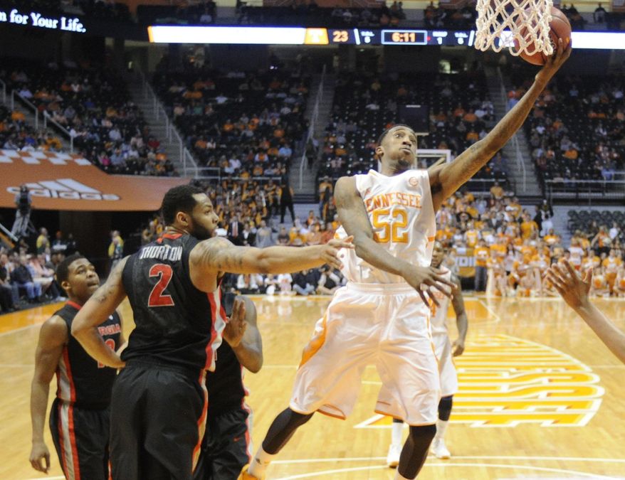 Tennessee guard Jordan McRae (52) scores past Georgia forward Marcus Thornton (2) during the first half at the Thompson-Boling Arena in Knoxville on Tuesday, Feb. 18, 2014. (AP Photo/The Knoxville News Sentinel, Adam Lau)
