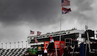 Crew members work on pit road under threatening skies during practice for Sunday&#39;s NASCAR Daytona 500 Sprint Cup series auto race in Daytona Beach, Fla., Friday, Feb. 21, 2014. (AP Photo/Terry Renna)