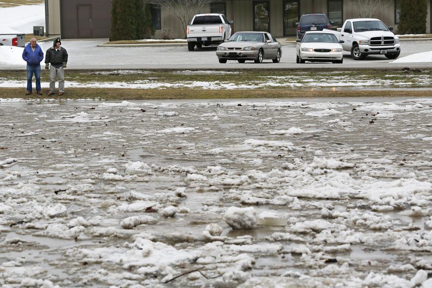 Two men survey the extent of the flooding from the Wildcat Creek Friday, Feb. 21, 2014, on Conservation Club Road in Lafayette, Ind. Authorities say an ice jam has caused a creek near Lafayette to overflow its banks, flooding several homes and prompting some evacuations. (AP Photo/Journal & Courier, John Terhune)