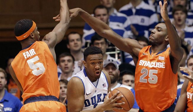 Duke&#x27;s Jabari Parker is pressured by Syracuse&#x27;s C.J. Fair (5) and Rakeem Christmas (25) during the first half of an NCAA college basketball game in Durham, N.C., Saturday, Feb. 22, 2014. (AP Photo/Gerry Broome)