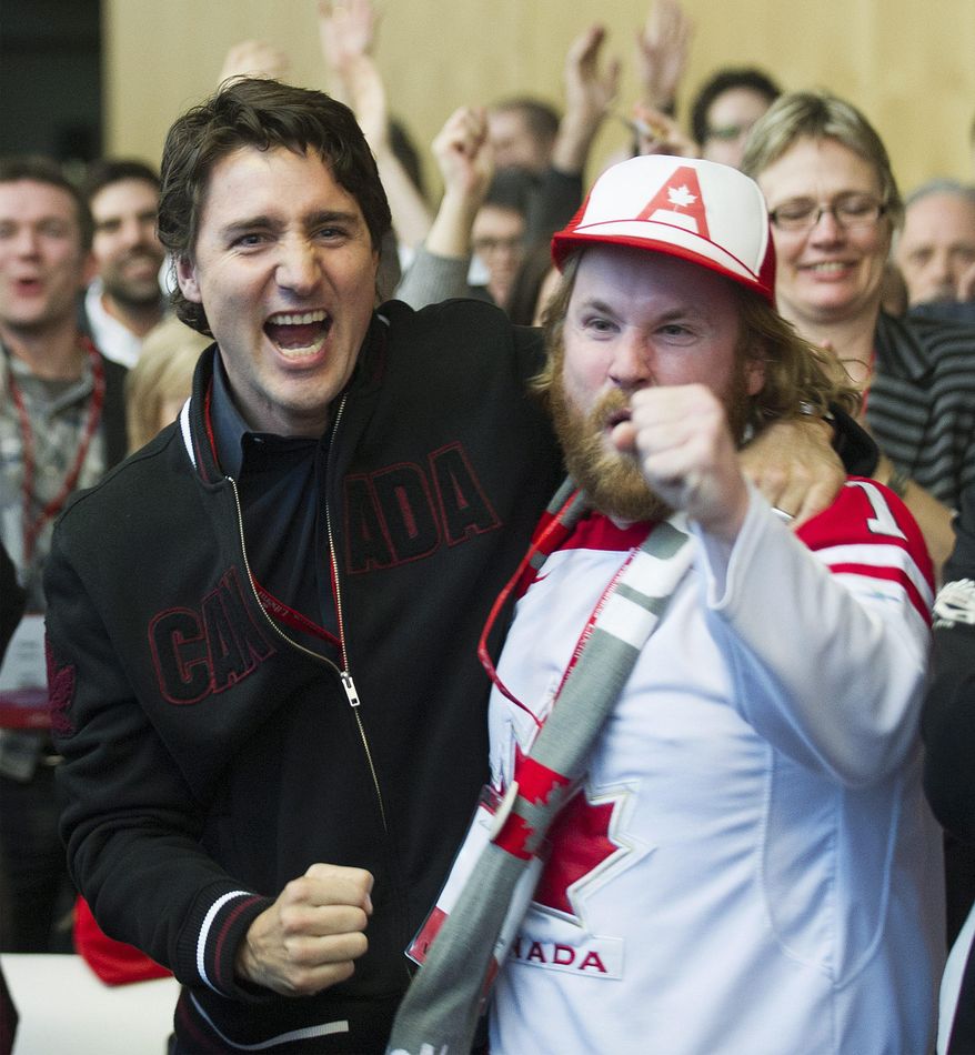 Federal Liberal leader Justin Trudeau, left, celebrates with Mike Burton as they watch team Canada beat team USA in the semifinal hockey game at the 2014 Sochi Winter Olympic Games on day two of the party&#39;s biennial convention in Montreal, Friday, Feb. 21, 2014. (AP Photo/The Canadian Press, Graham Hughes)
