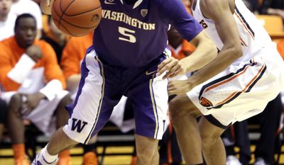 Washington guard Nigel Williams-Goss, left, drives to the hoop past Oregon State guard Hallice  Cooke during the first half of an NCAA basketball game in Corvallis, Ore., Saturday, Feb. 22, 2014.(AP Photo/Don Ryan)