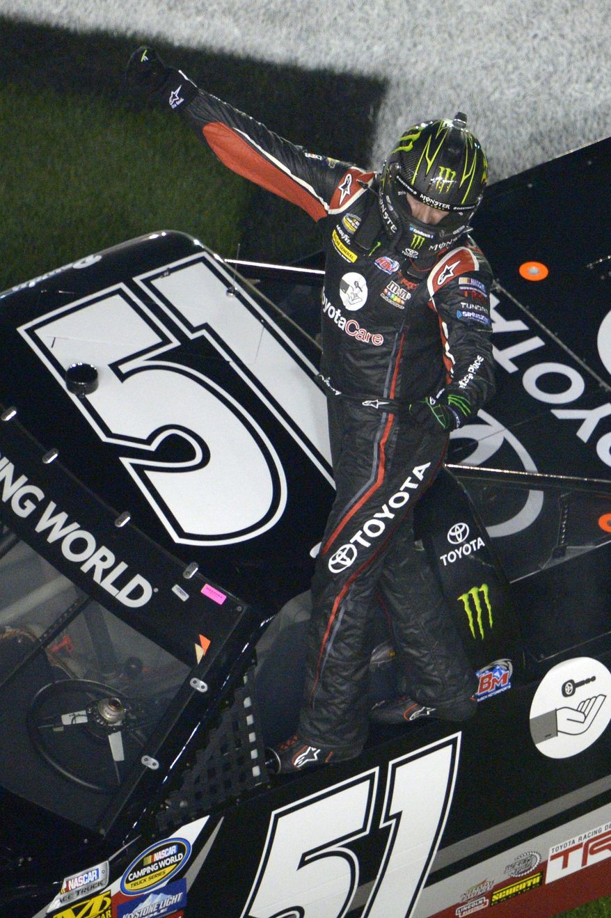 Kyle Busch (51) celebrates while standing on his truck in the infield after winning the NASCAR Truck Series auto race at Daytona International Speedway in Daytona Beach, Fla., Friday, Feb. 21, 2014. (AP Photo/Phelan M. Ebenhack)