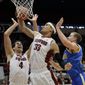 Stanford forward Dwight Powell (33) grabs a rebound next to teammate Stefan Nastic (4) and UCLA forward Travis Wear during the first half of an NCAA college basketball game on Saturday, Feb. 22, 2014, in Stanford, Calif. (AP Photo/Marcio Jose Sanchez)