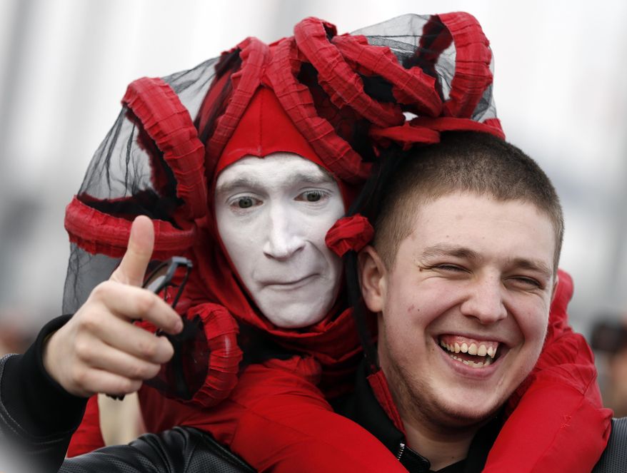 A street performer poses for a picture with a fan in Olympic Park at the 2014 Winter Olympics, Saturday, Feb. 22, 2014, in Sochi, Russia. (AP Photo/Mark Humphrey)