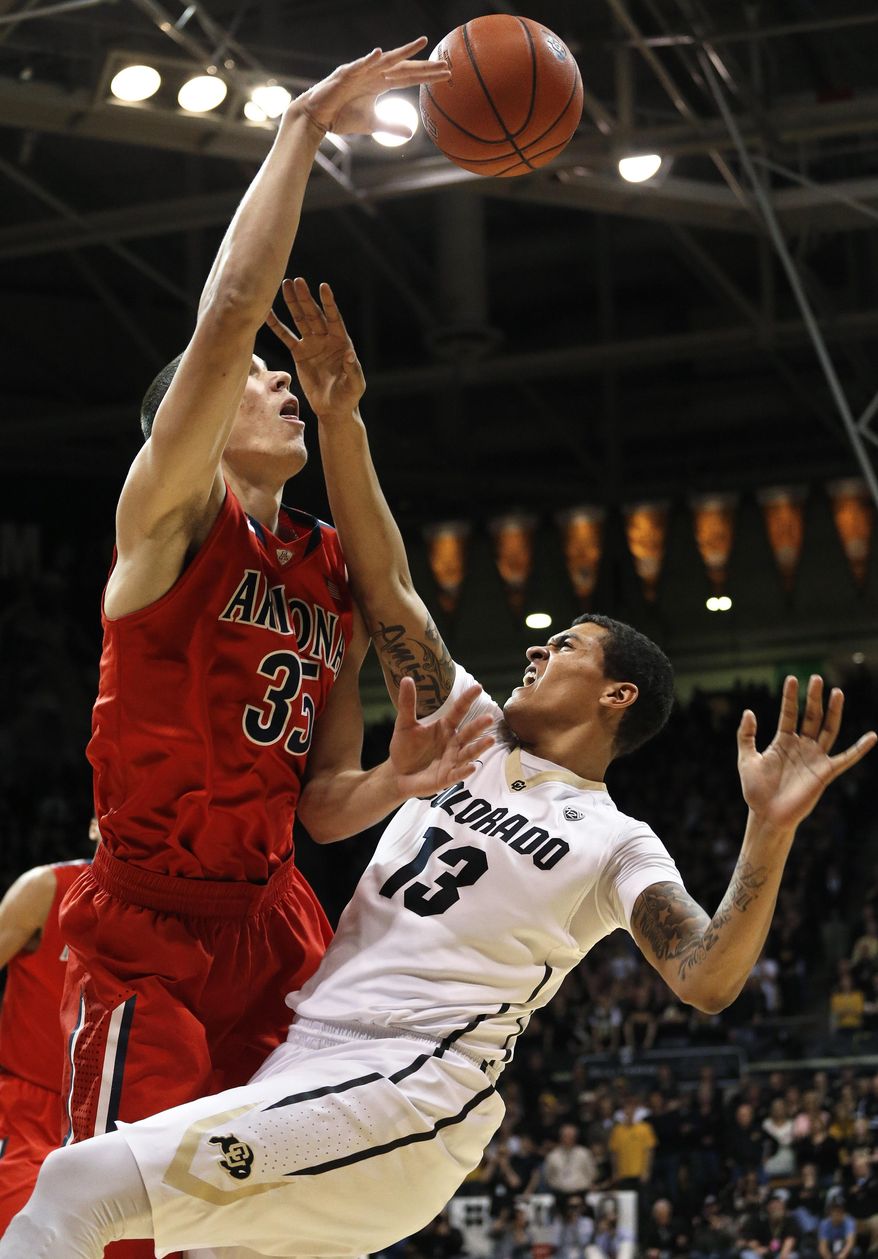 Arizona's Kaleb Tarczewski blocks a shot by Colorado's Dustin Thomas during the first half of an NCAA college basketball game, in Boulder, Colo., Saturday, Feb. 22, 2014. (AP Photo/Brennan Linsley)